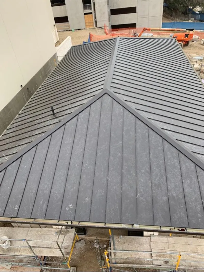 Commercial metal roof construction with crane equipment in Ontario